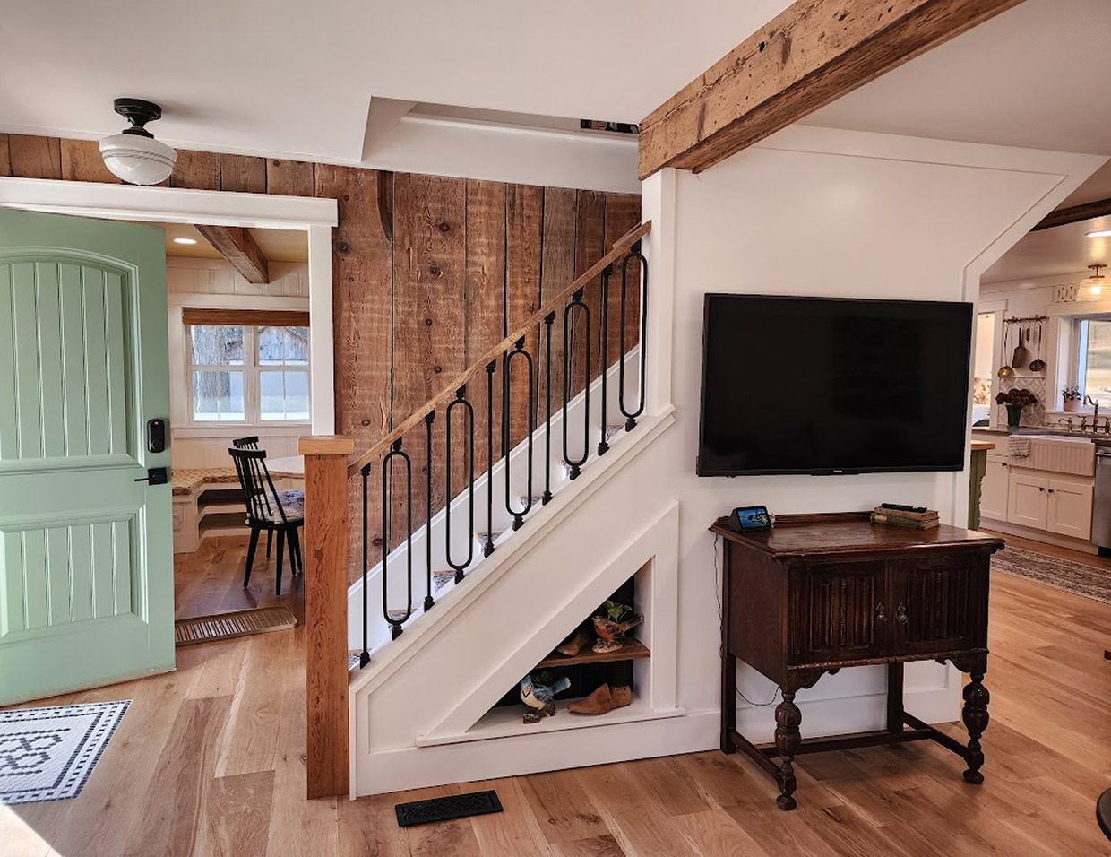 Rustic living room with staircase and decor.