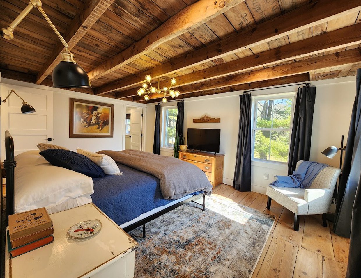 Cozy bedroom with wooden ceiling and decor.