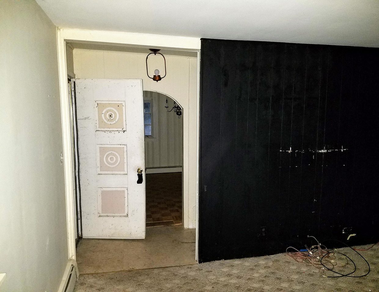 Empty room with open door and archway.