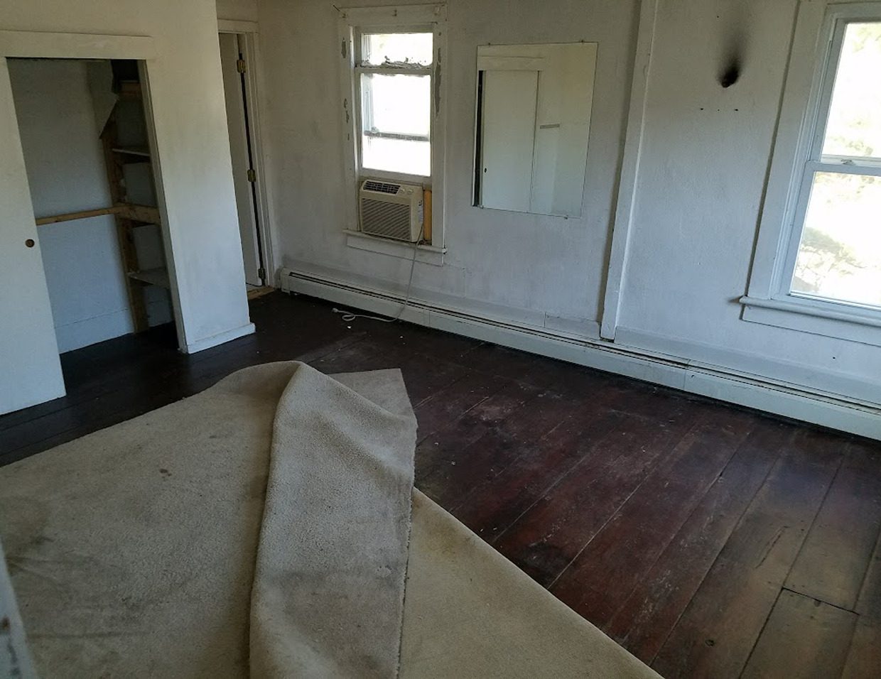 Empty room with old carpet and windows.