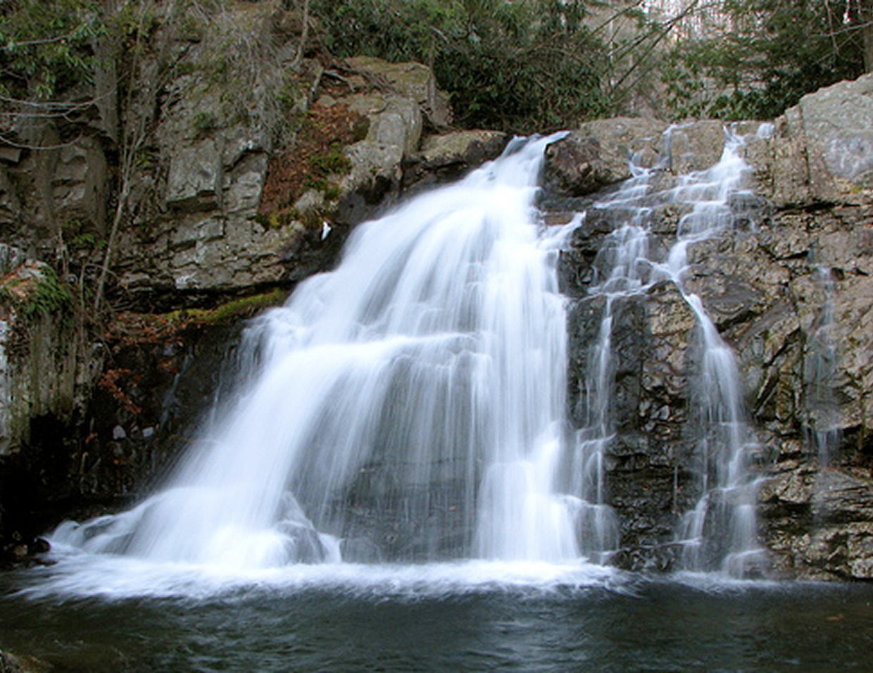 Waterfall cascading over rocks in forest.