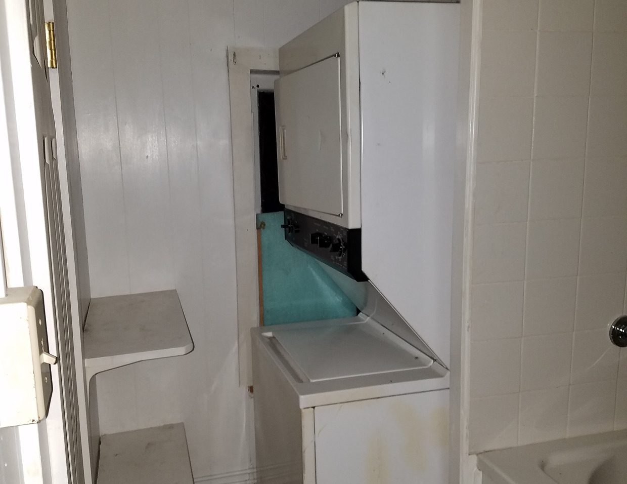 Stacked washer and dryer in small space.