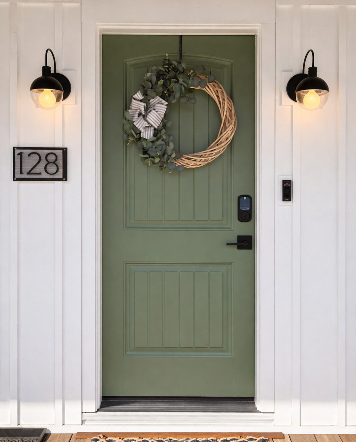 Green door with wreath and house number.
