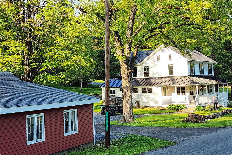 White house and red building amidst trees.