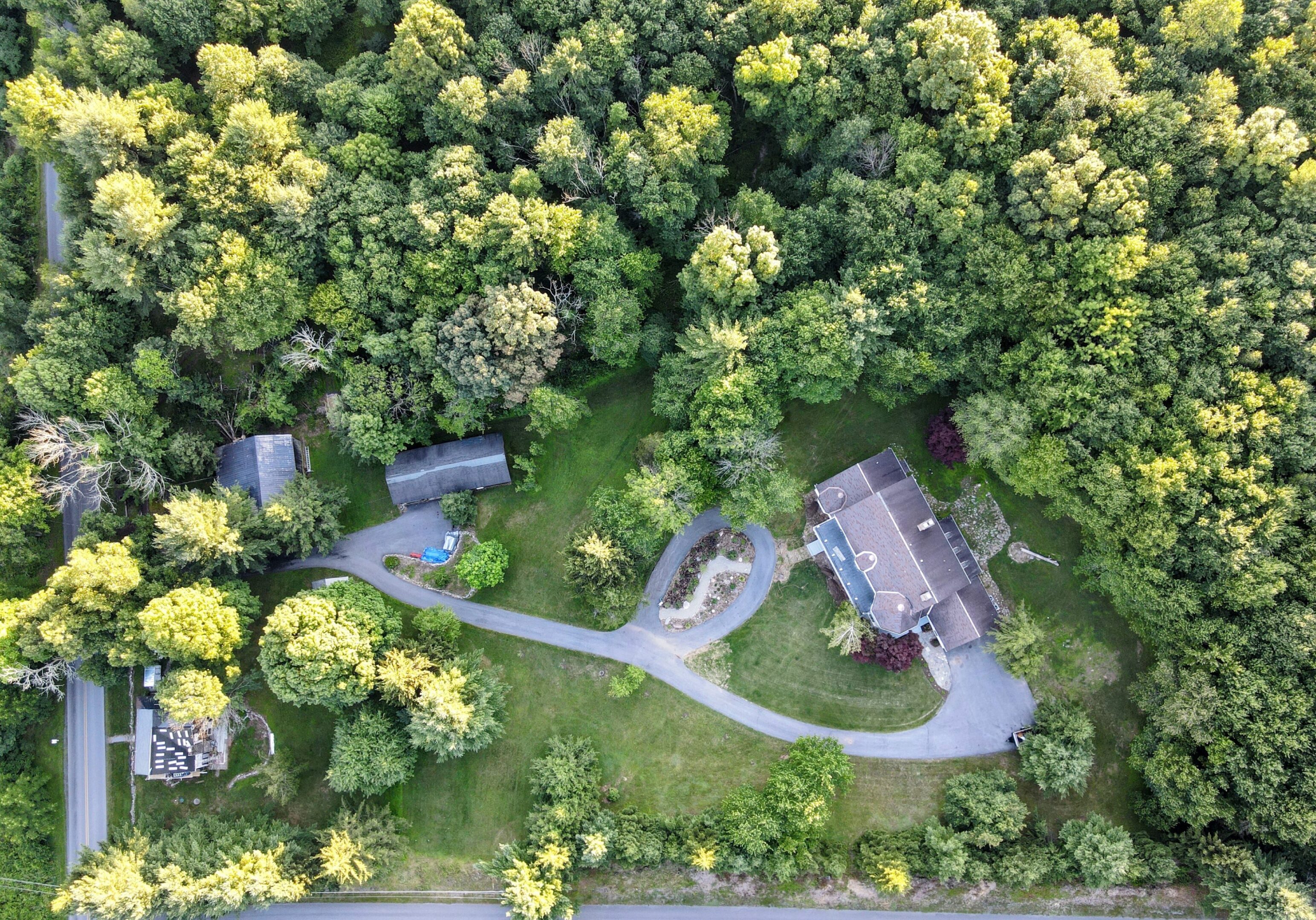 Aerial view of house surrounded by trees.